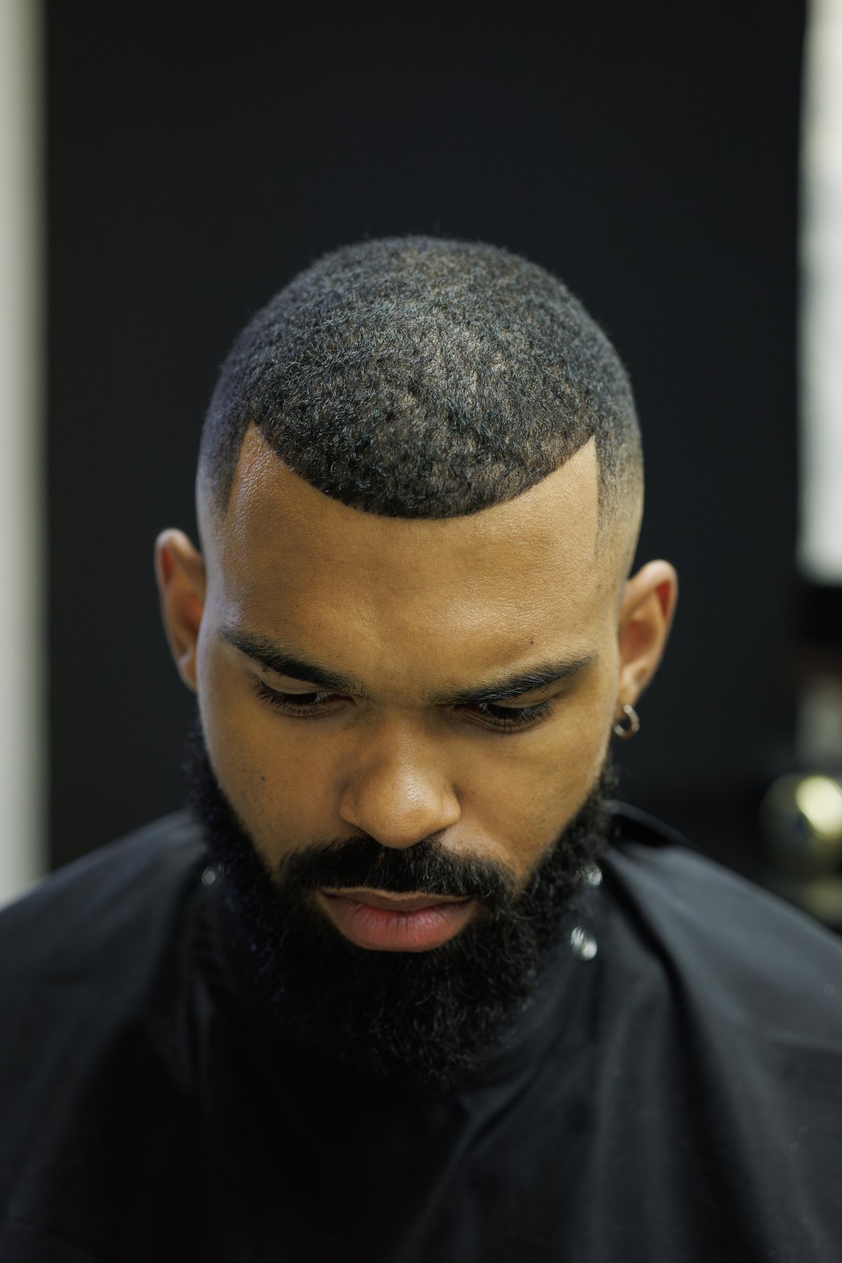 Portrait of a man with a fresh haircut sitting in the barbershop